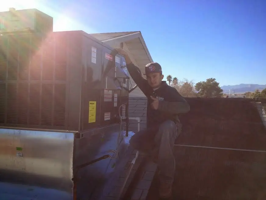 HVAC technician performing Air Duct Repair on a rooftop unit in Crawford
